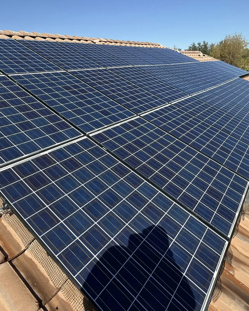 Clean, well-maintained residential solar array on a tile roof in Arizona under a clear sky