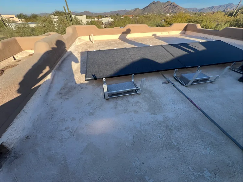 Solar panels detached and staged on a Scottsdale flat foam roof before roof work