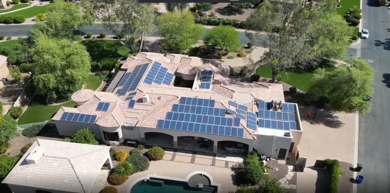 Aerial view of a large Arizona tile-roof home with multiple solar arrays