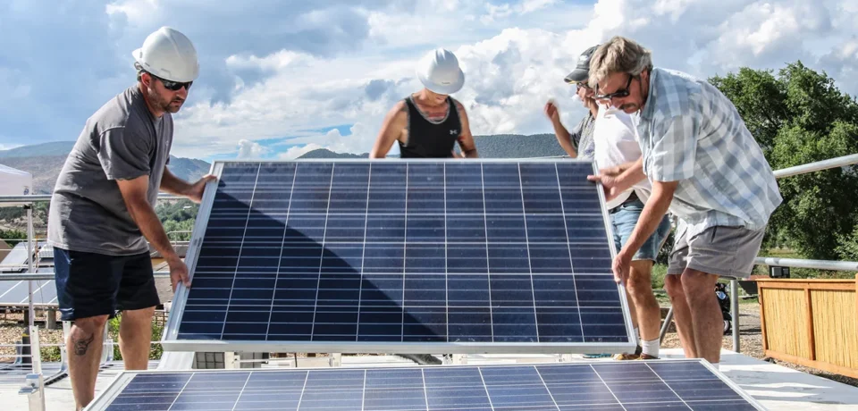 Workers installing solar panels on a rooftop, showcasing teamwork and expertise in solar energy solutions for sustainable projects.