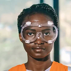Woman wearing safety goggles and an orange vest, representing professionalism and safety in solar energy installations.