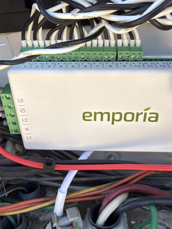 Emporia energy monitoring device with connected wires, showcasing real-time solar system performance tracking for optimized energy management.