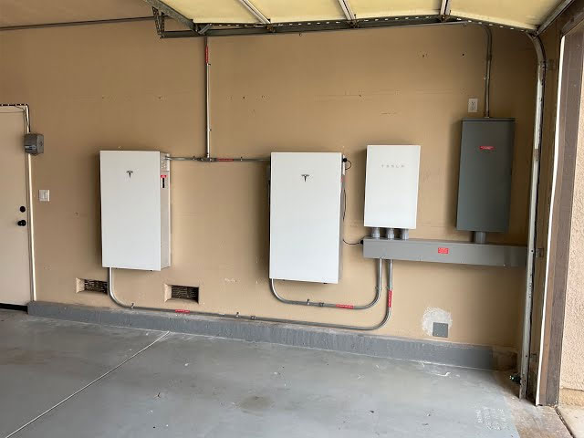 Tesla Powerwall installation in garage, featuring two Powerwall units and an inverter, demonstrating smart energy storage and optimization for Arizona homes.