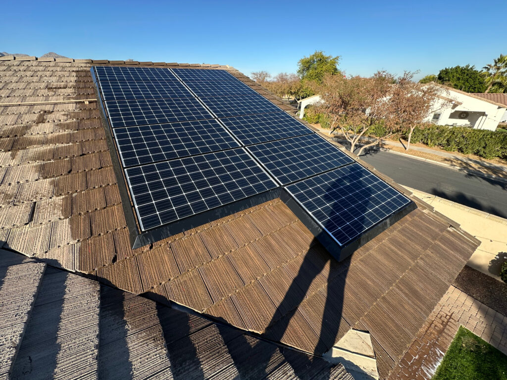 Solar panels installed on a sloped roof in Arizona, showcasing a clear blue sky and surrounding residential area, highlighting solar system inspection services.
